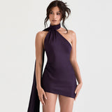 woman wearing a dark purple one-shoulder mini dress with a halter neckline and draped back detail