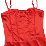 Close-up of the red satin corset bodice of a dress, showing boning and a zipper.