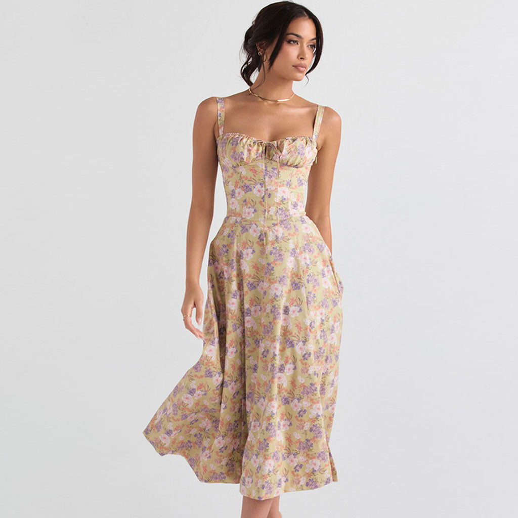 Full-length view of a woman in a yellow floral print midi dress, showing the flow of the skirt