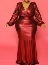 Woman wearing a long red metallic dress with long balloon sleeves and a V-neckline