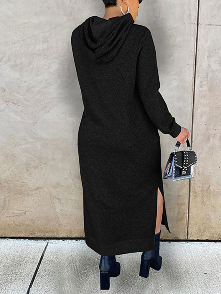 Rear view of a woman wearing a long black hooded dress with side slits.