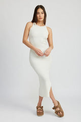 Full body shot of a woman in a white ribbed knit midi dress, paired with platform sandals, against a light grey background.