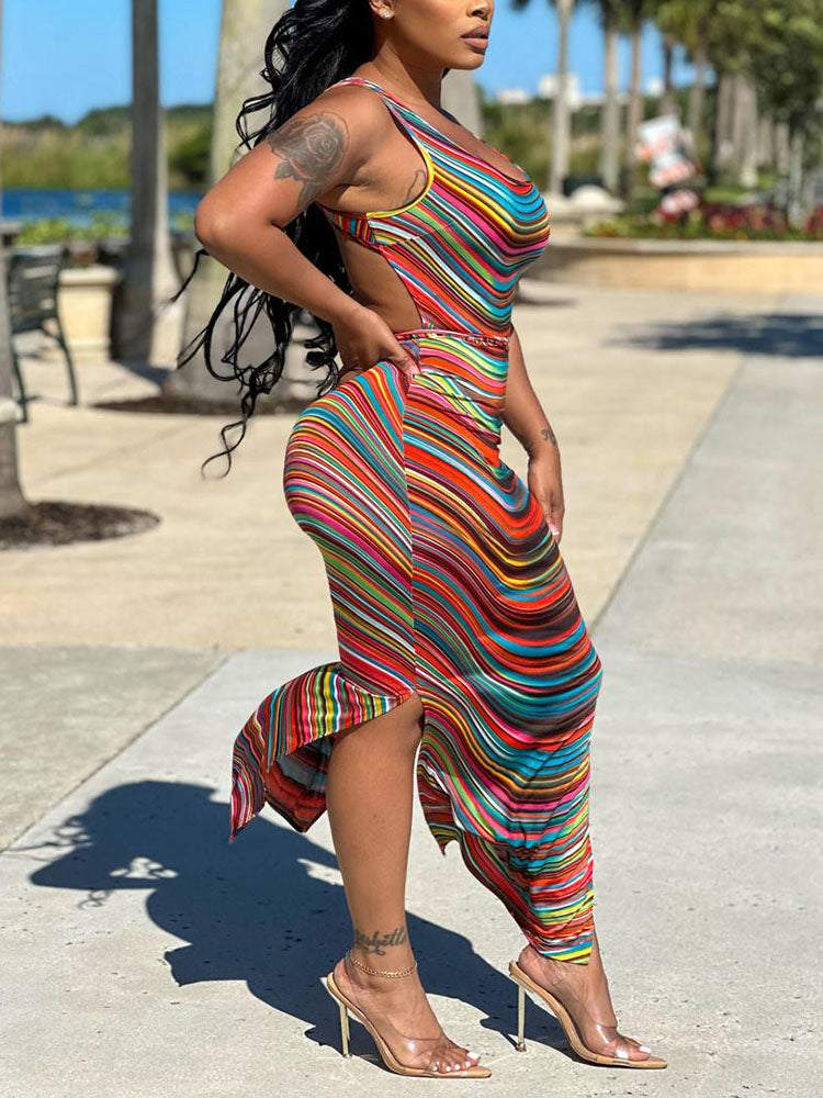 Side view of a woman in a vibrant striped sleeveless dress with a high slit.