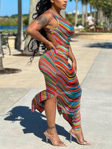 Side view of a woman in a vibrant striped sleeveless dress with a high slit.