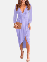 Woman wearing a lavender long-sleeve V-neck ruched waist dress with an asymmetrical hem and a clutch bag.