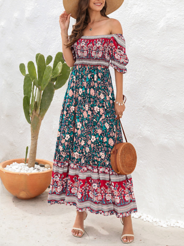 Woman wearing a floral print off-the-shoulder maxi dress with puff sleeves, a tiered skirt, and a straw hat, holding a straw bag.
