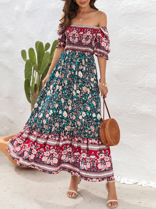 Woman wearing a floral print off-the-shoulder maxi dress with puff sleeves and a tiered skirt, holding a straw bag.