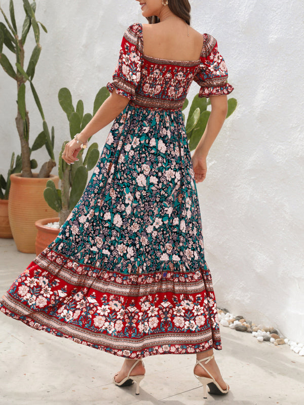 Rear view of a woman in a floral print off-the-shoulder maxi dress with puff sleeves and a tiered skirt.