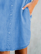 close-up of the button-down front and side pocket of a blue denim shirt dress