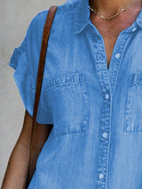 close-up of the collared neckline and chest pockets of a blue denim shirt dress