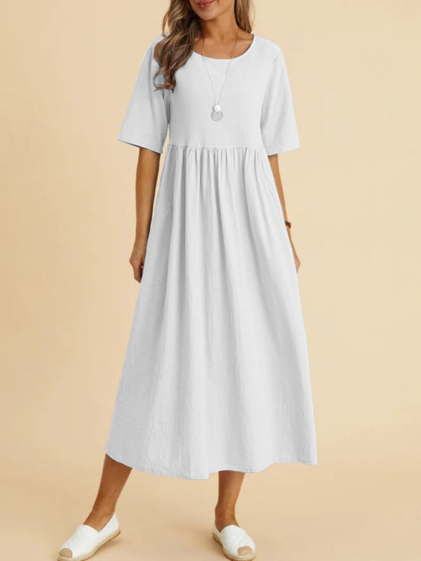 woman wearing a white midi dress with short sleeves and a round neckline