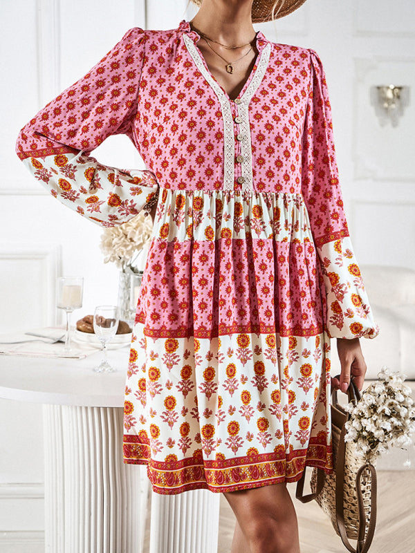 Woman wearing a pink and white floral print tiered mini dress with long bell sleeves and a V-neck.