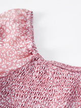 Close-up of the smocked bodice and neckline of the pink floral dress.