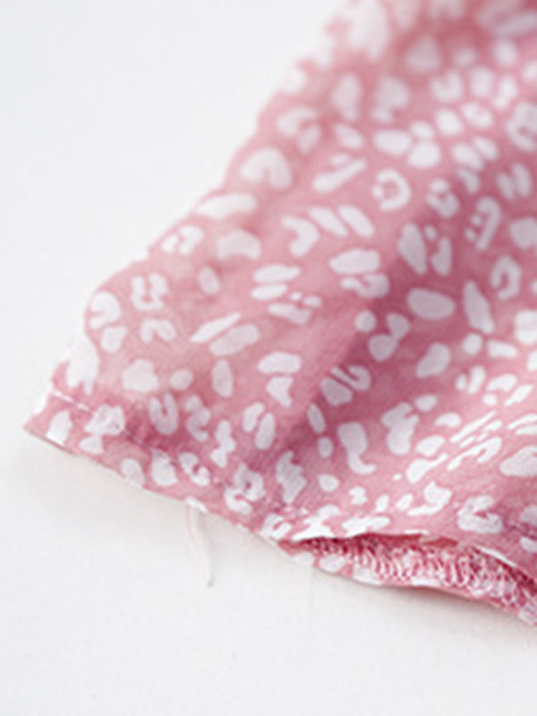 Detail of the hemline of the pink floral dress, showing the fabric and stitching.