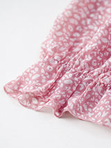 Close-up of the ruffled sleeve hem of the pink floral dress.