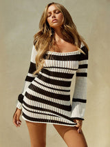 Woman wearing a black and white striped crochet knit mini dress with long bell sleeves and a square neckline.