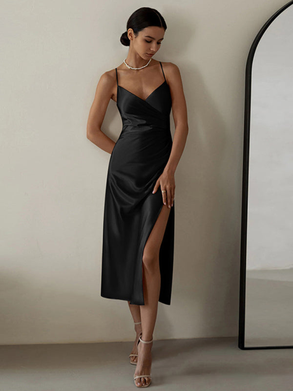 woman wearing a black satin slip dress with spaghetti straps and a high slit