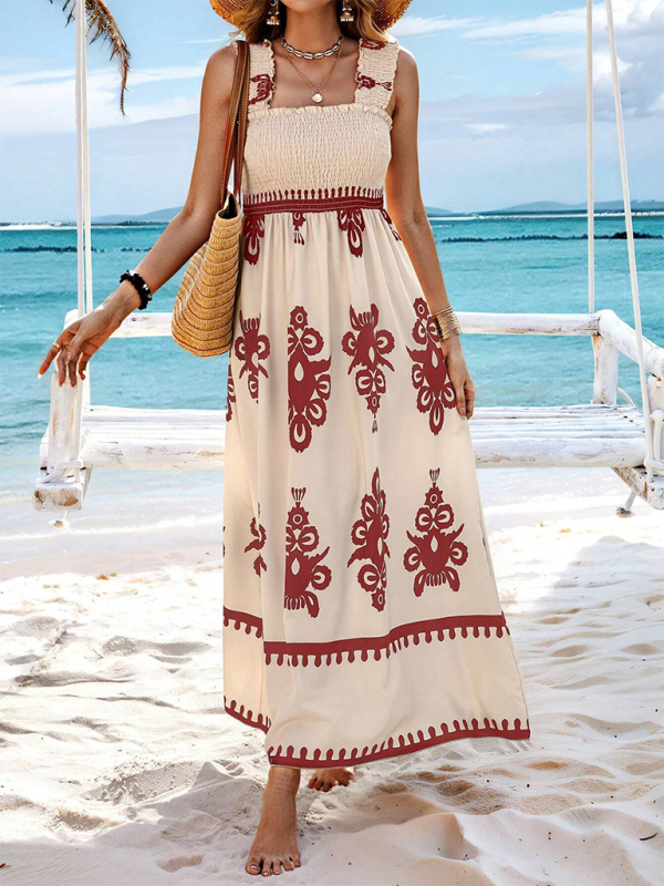 Woman wearing a cream and maroon floral print maxi dress with smocked bodice and square neckline on a beach.