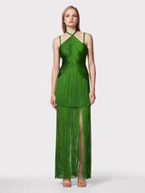 front view of a woman wearing a long green halter neck dress with tiered fringe and a high leg slit