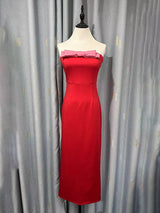 Red strapless midi dress with a pink bow accent displayed on a mannequin.