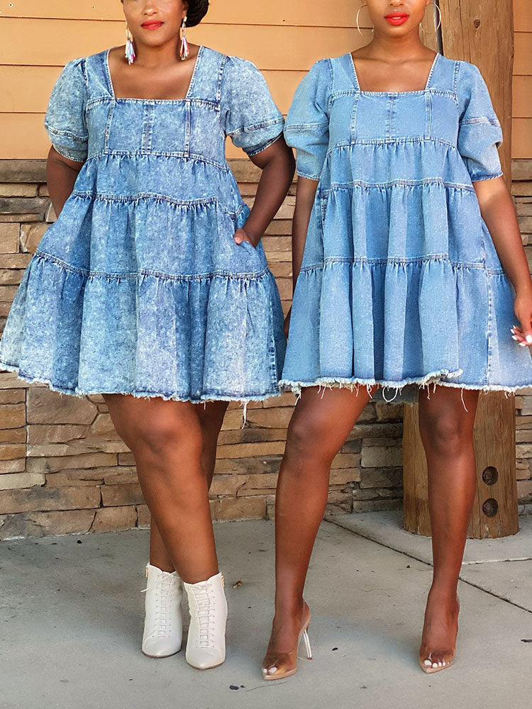 woman wearing a blue denim tiered babydoll dress with puff sleeves and a square neckline