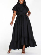 Plus-size model wearing a black maxi dress with ruffled details.
