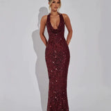Woman wearing a long burgundy sequined halter dress