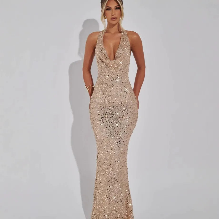 Woman wearing a long gold sequined halter dress