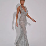 Woman wearing a long silver sequined halter dress