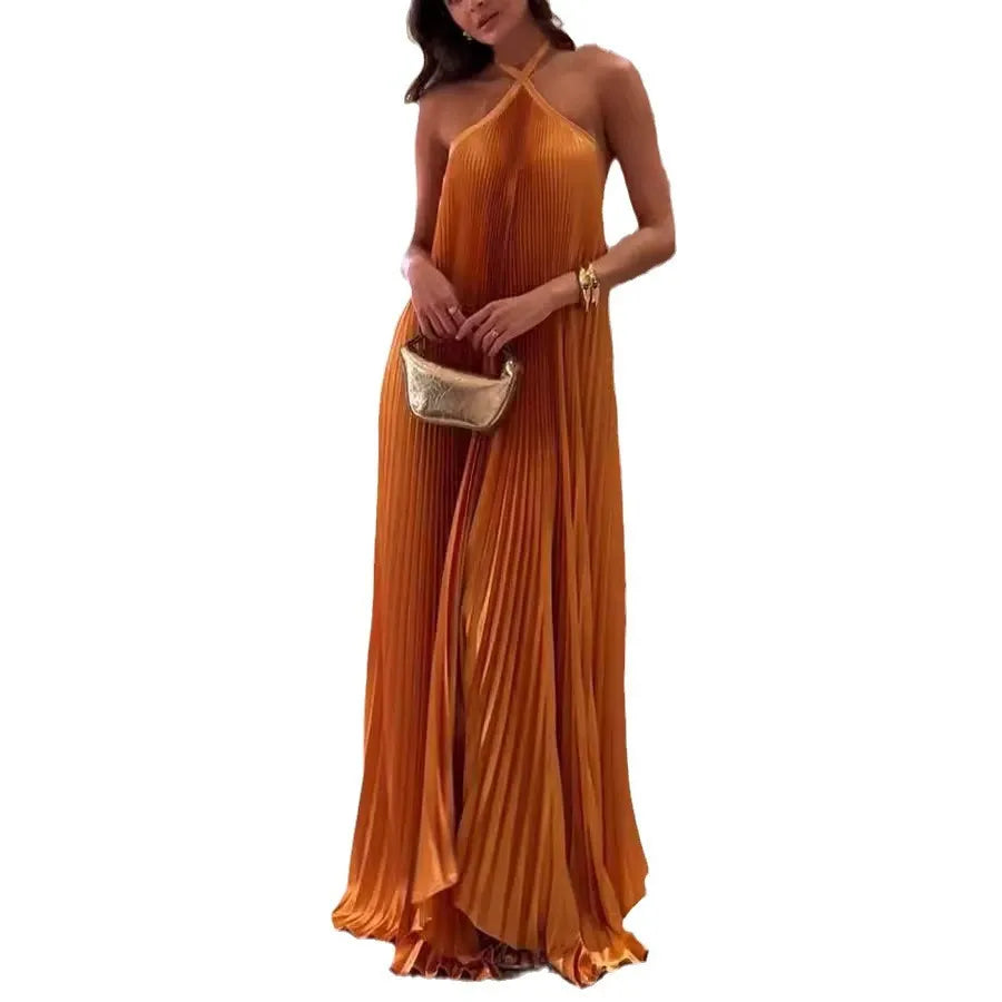 woman in orange pleated halter maxi dress with gold clutch, full body