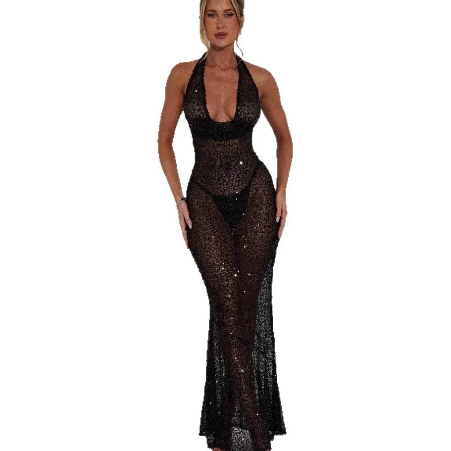 Woman wearing a long sheer black sequined halter dress