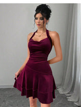 Woman wearing a maroon velvet halter dress with a layered skirt