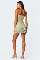back view of a woman in a green strapless lace mini dress