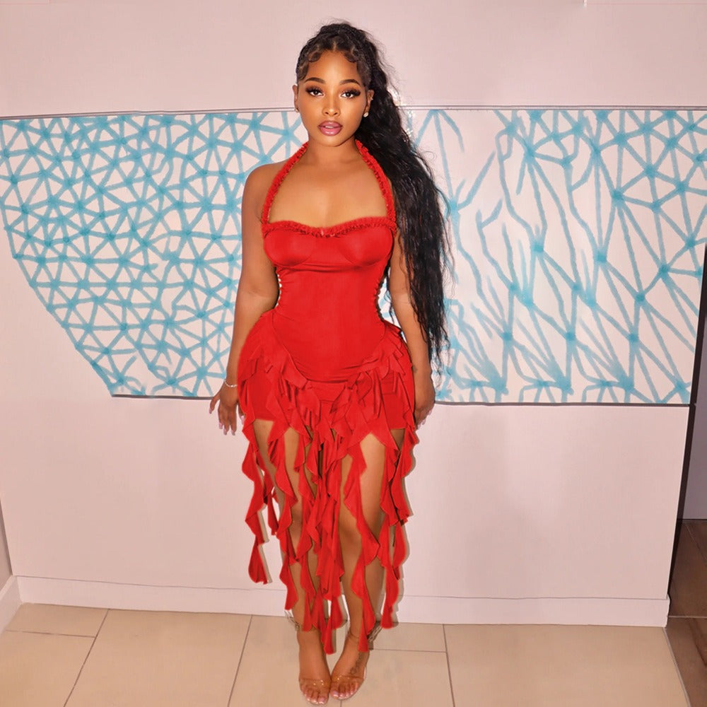 Woman wearing a red halter dress with ruffled trim and a fringed hem