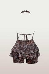 Back view of a leopard print halter romper with a tiered ruffled skirt and tie-back straps.
