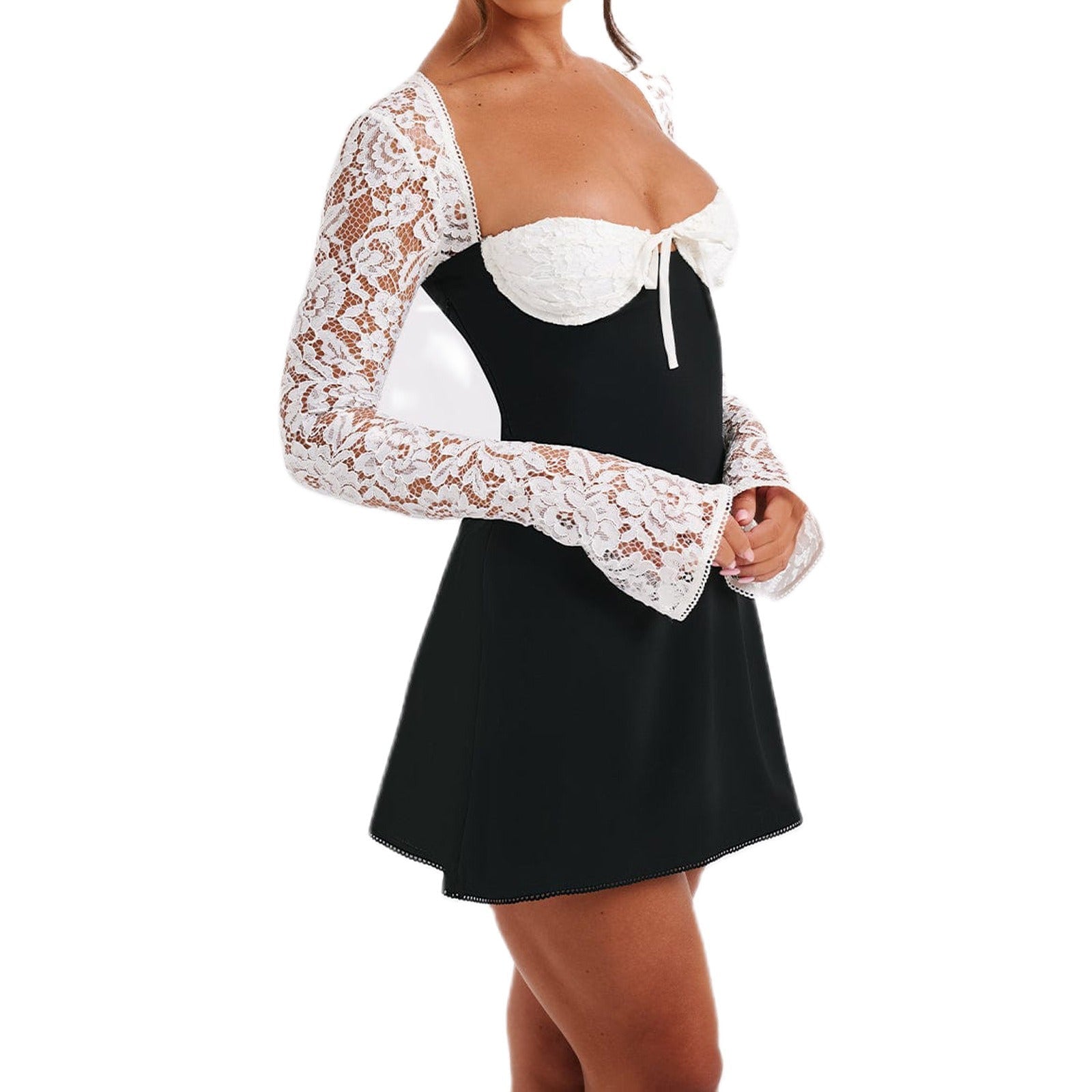 Woman wearing a black and white mini dress with white lace sleeves and a white bow detail, slightly angled front view