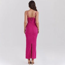 back view of a woman wearing a long fuchsia ribbed knit dress with lace trim and lace-up detail