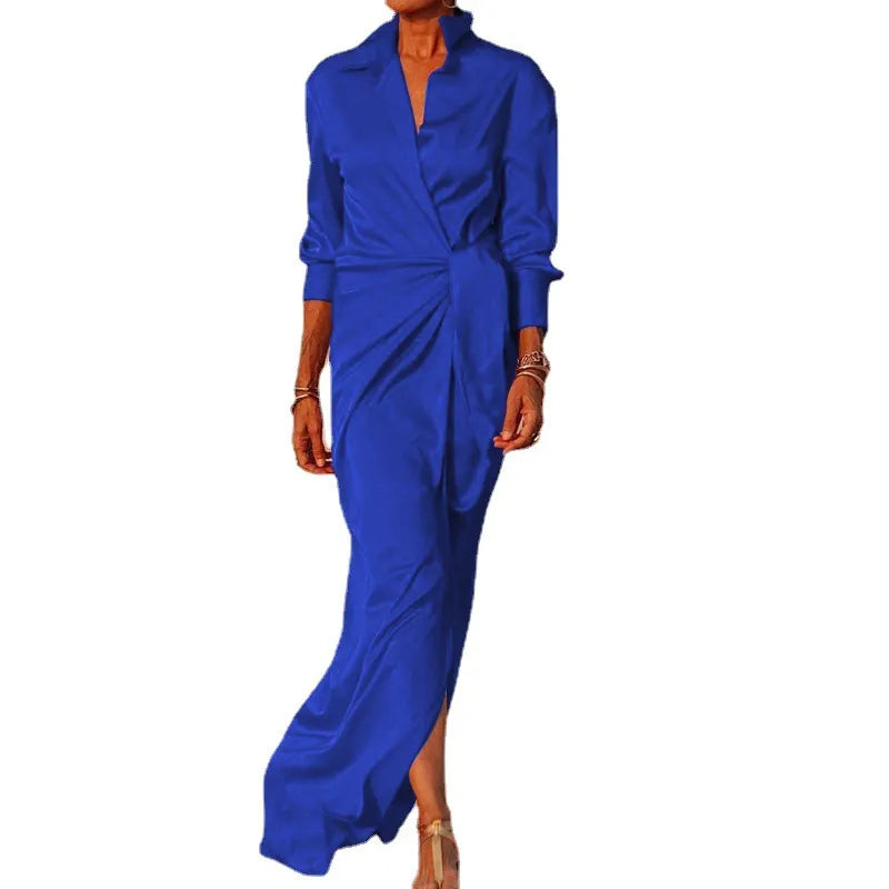 Woman wearing a long blue satin dress with a V-neck and long sleeves.