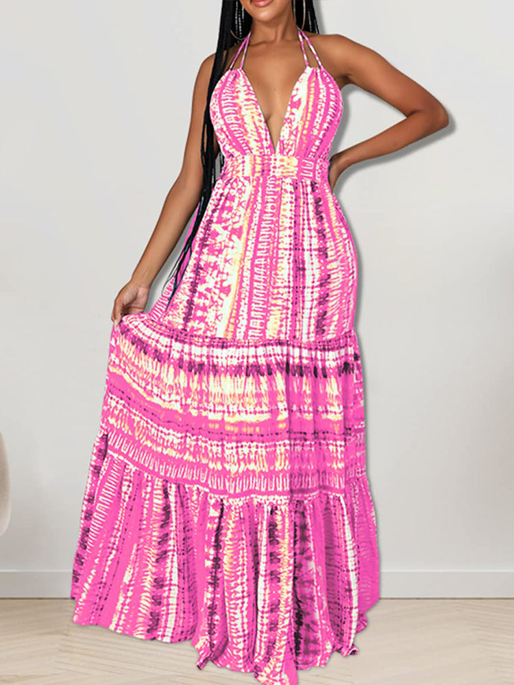 Woman wearing a long pink tie-dye halter neck dress with a tiered skirt