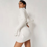 Side view of a woman in a white ribbed knit long sleeve bodycon dress