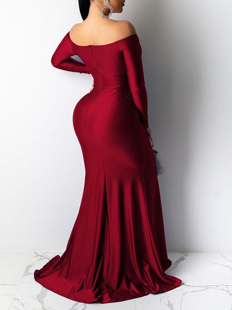 Back view of a woman in a red off-the-shoulder long-sleeved mermaid gown with a high slit