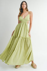 woman wearing a lime green maxi dress with spaghetti straps and cutout details