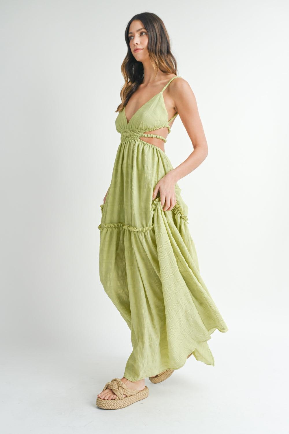 woman in a flowing lime green maxi dress with cutout sides and ruffled tiers