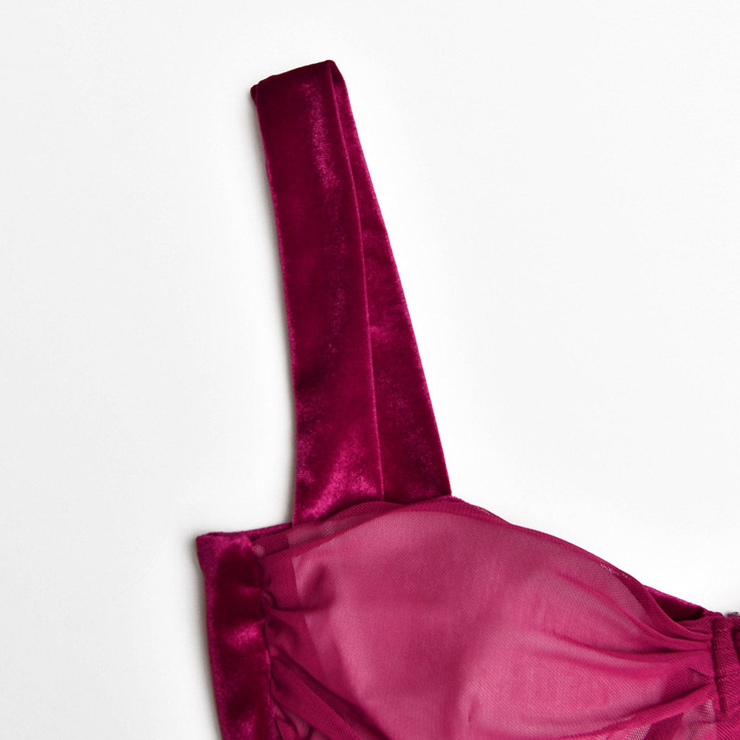 close-up of a spaghetti strap on a burgundy ruched velvet and mesh dress