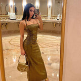 Woman taking a mirror selfie in a shimmering gold maxi dress, holding a handbag.