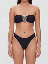 Front view of a black strapless bikini top with ruched fabric and a silver decorative accent, paired with matching high-cut bikini bottoms.