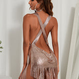 woman wearing a rose gold metallic mesh mini dress with fringe hem and cowl neck from the back