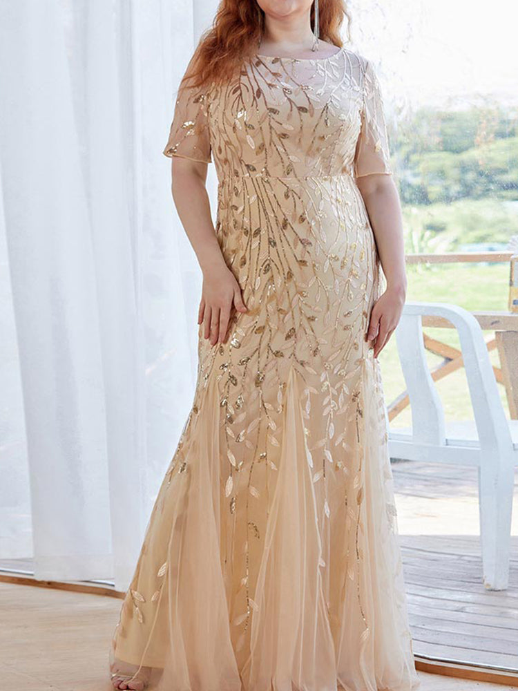 Woman wearing a gold sequined mermaid gown with short sleeves and a scoop neckline.