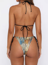 Back view of a woman wearing a printed triangle bikini with black string ties.