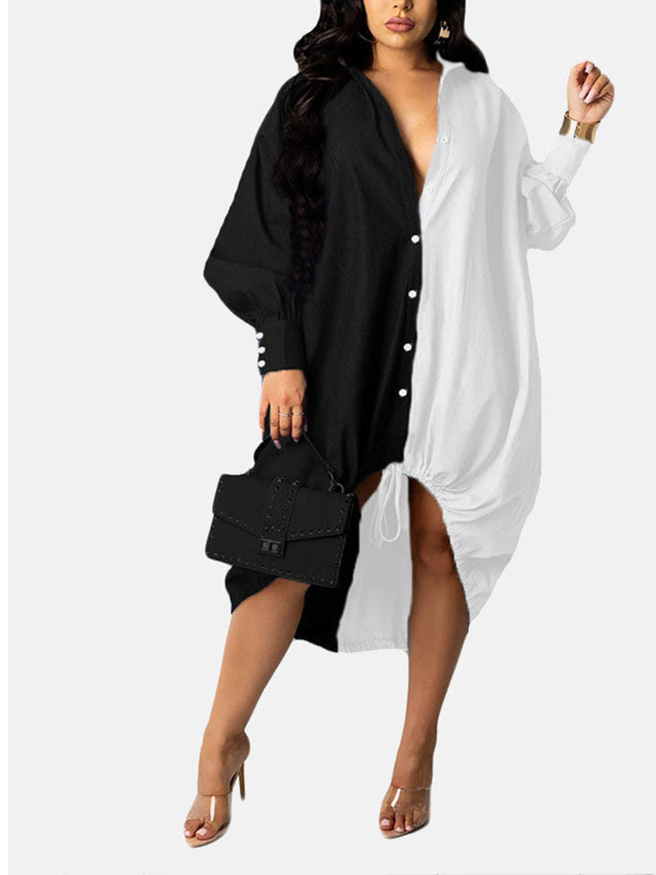 Woman wearing a black and white color-blocked oversized shirt dress with button-down front and adjustable drawstring hem, holding a black handbag.